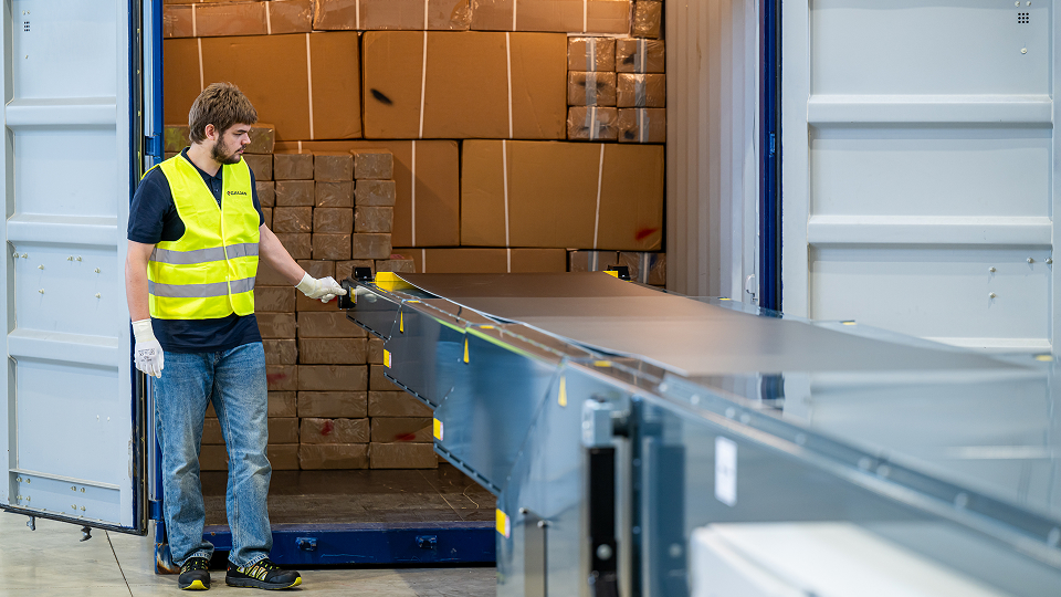un opérateur qui déploie le convoyeur télescopique Caljan Classic dans la remorque