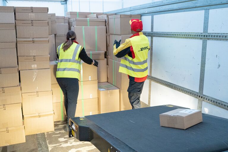 Two operators unloading a trailer with the help of Caljan Droop Snoot