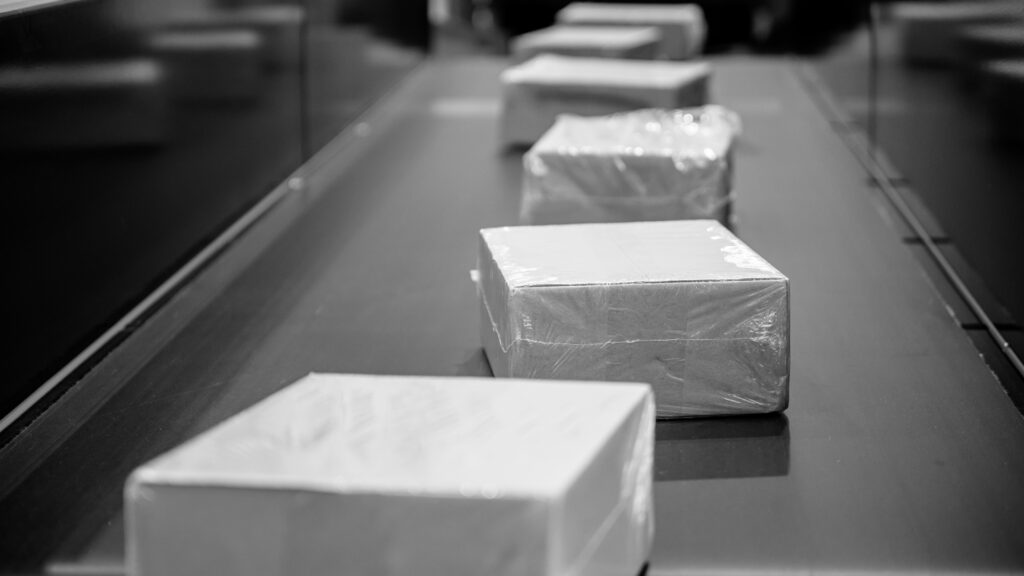 boîtes transportées sur un tapis roulant